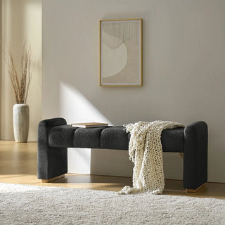 Black boucle ottoman placed in neutral living room with cream decor accents showing styling possibilities