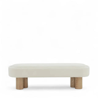 Front view of white boucle upholstered bench with plush cushioned seat and natural wood cylindrical legs