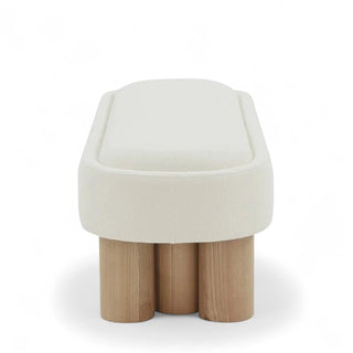 Side angle of white boucle bench showing curved seat edge and solid wood legs
