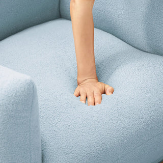 Person demonstrating the plush comfort of light blue boucle armchair cushion