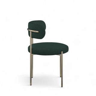 Angled side view of green boucle dining chair with gold frame