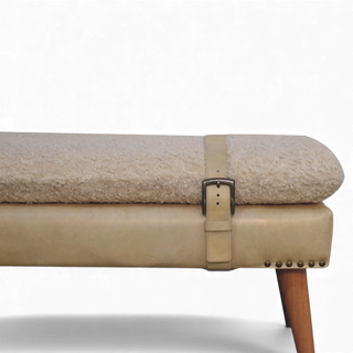 Beige cushioned bench with a strap and wooden leg on a white background