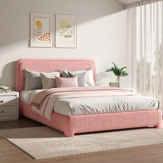Blush pink boucle bed frame with rounded corners styled with neutral bedding and abstract wall art