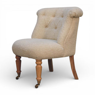Beige upholstered chair with wooden legs on a white background