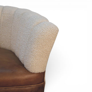 Close-up of a brown leather chair with a textured beige cover on a white background