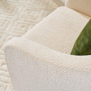 Detail view of ivory boucle swivel chair showing texture of fabric and curved armrest design