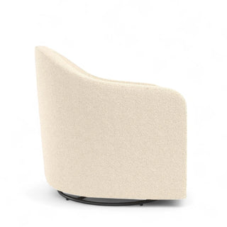 Side view of ivory boucle swivel chair showing curved barrel design and ergonomic proportions