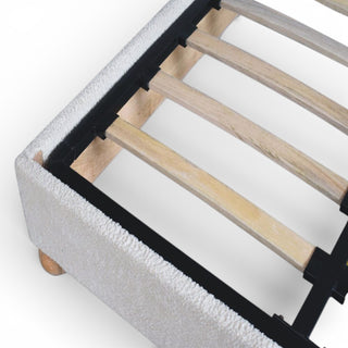 Gray upholstered bed frame with wooden slats on a white background