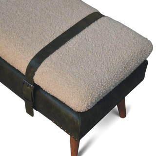 Footstool with sheepskin cover and black leather trim on a white background