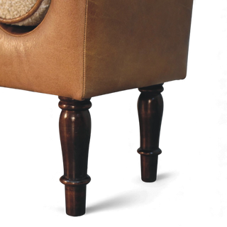 Close-up of a brown upholstered chair with wooden legs on a white background