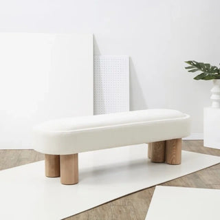 White boucle bench positioned at foot of bed in neutral bedroom setting