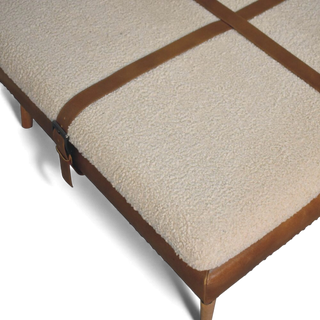 Beige upholstered ottoman with brown wooden frame on a white background