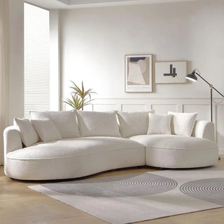Boucle couch in a bright modern living room with wooden flooring and wall decor.