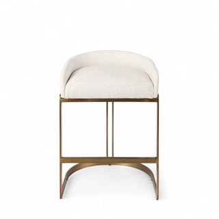 Cream boucle counter stool with curved bucket seat and brass-finished metal base showing alternative color option