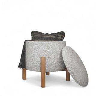 Light gray boucle storage ottoman with lid partially open showing interior storage compartment