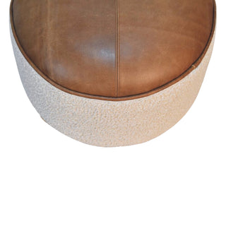 Round ottoman with brown leather top and textured beige base on a white background