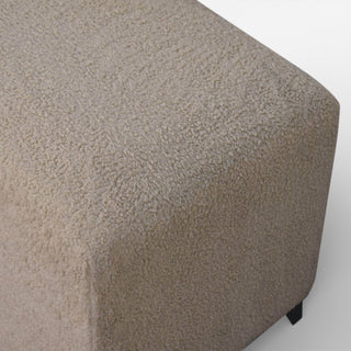 Hexagonal ottoman with textured beige surface on a white background