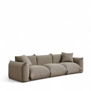 Mid-century modern boucle sofa in mocha featuring plush oversized cushions, rounded arms, textured fabric, and clean lines with decorative throw pillows against white background