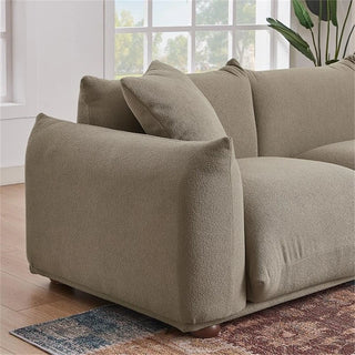 Side view of mocha boucle sofa showing sleek silhouette and solid wood legs