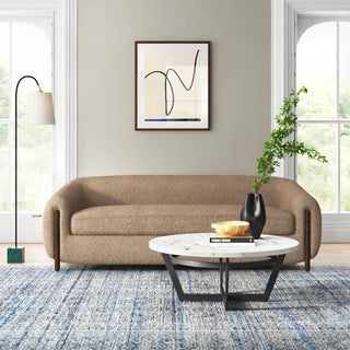 Neutral boucle sofa styled in modern living room with coffee table and minimalist decor