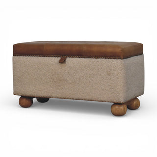 Storage ottoman with brown leather top and wooden legs on a white background
