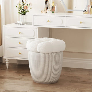 Boucle ottoman placed in front of a vanity desk, showcasing its soft texture and elegant round shape.