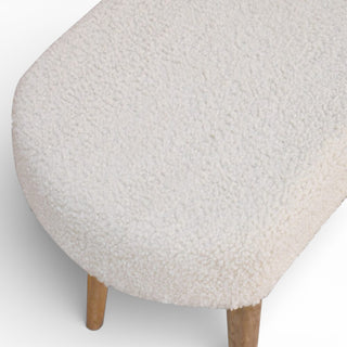 Round ottoman with textured beige cushion and wooden legs on a white background