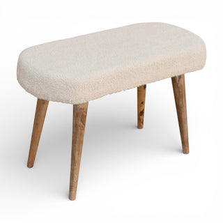 Beige upholstered bench with wooden legs on a white background