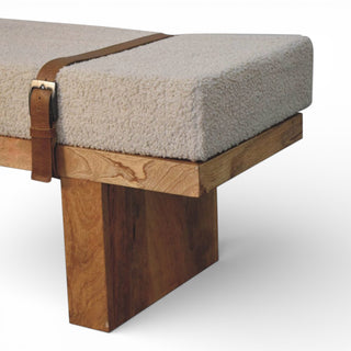 Wooden bench with a cushioned seat and leather strap on a white background