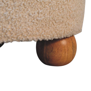 Close-up of a textured beige surface with a wooden leg on a white background