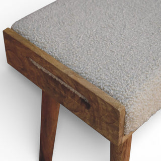 Wooden stool with a textured gray cushion on a white background