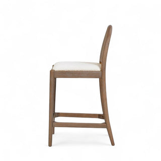 Side profile of oak counter stool showing curved silhouette, cane backrest, and brass footrest detail