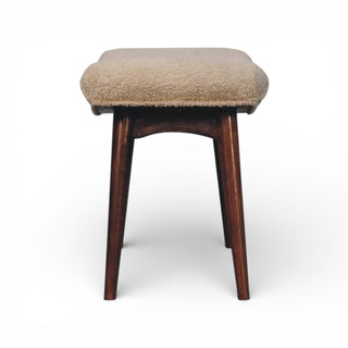 Stool with brown cushioned top and wooden legs on a white background