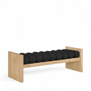 Black boucle bench with nine roll cushions on natural wood H-frame