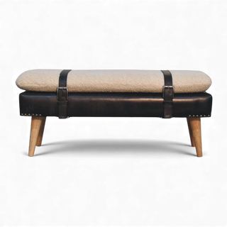 Bench with beige cushion, black straps, and wooden legs on a white background