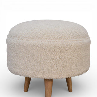 Round ottoman with fluffy beige cushion and wooden legs on a white background