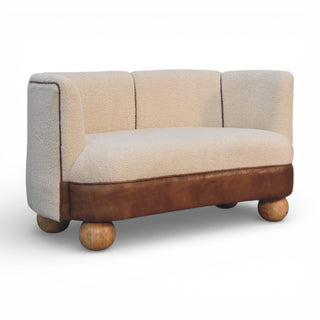 Small two-seater sofa with a mix of fabric and leather on a white background