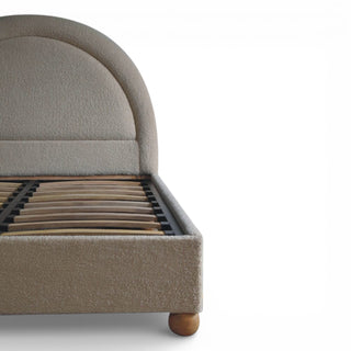 Gray upholstered bed frame with wooden slats on a white background