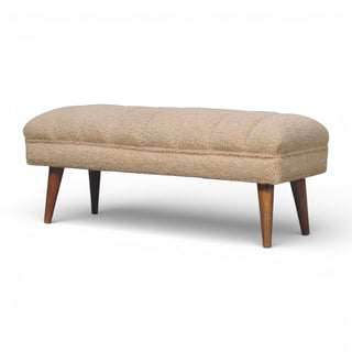 Beige upholstered bench with wooden legs on a white background