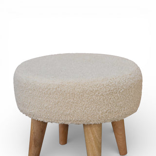 Round ottoman with beige cushioned top and wooden legs on a white background