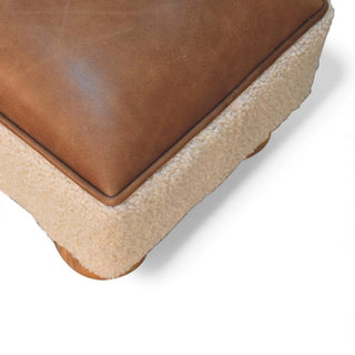 Close-up of a brown leather and beige fabric corner piece on a white background