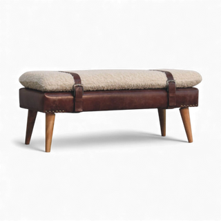 Close-up of the cream bouclé bench corner showing the brown buffalo leather strap, belted accent, and oak-style Nordic wood leg.