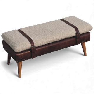 Angled view of the cream bouclé bench with brown buffalo leather strap accents across the slim cushioned seat and oak-style Nordic wood legs.