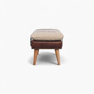 Side view of the cream bouclé bench with brown buffalo leather strap accents and Nordic solid wood legs in an oak-style finish.