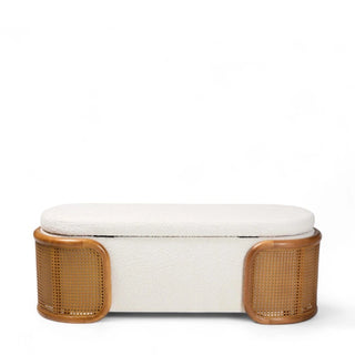 Cream boucle storage bench with woven rattan sides and curved legs shown from front angle in bedroom setting
