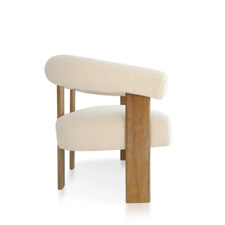 Side view of curved loveseat displaying distinctive silhouette, oak wood supports, and beige boucle upholstery