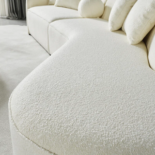 Close-up of premium white boucle fabric texture on sectional sofa showing dimensional weave pattern