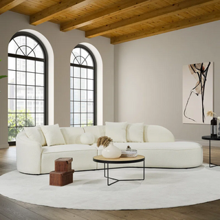 Complete room setting featuring curved boucle sectional in spacious interior with architectural details