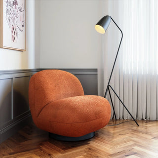 Terracotta sculptural lounge chair in a contemporary room setting with herringbone flooring and modern lighting