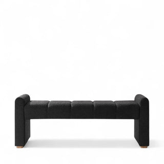 Front profile of black boucle ottoman showing piano key design detail and wooden leg construction